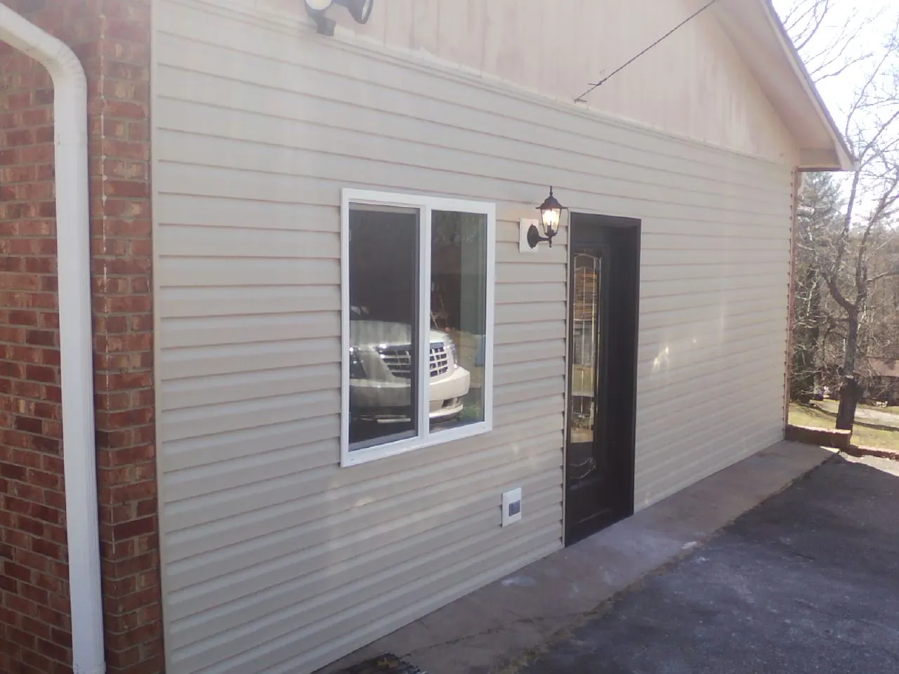 New vinyl siding and entry door on a room addition in Monroe